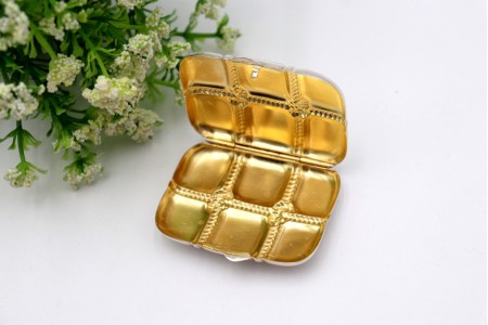 Caixa de comprimidos em prata com forma de mala de viagem com relevos e interior